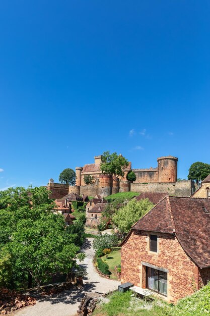 Estrada que conduz através da pequena aldeia à fortaleza Chateau de Castelnau Bretenoux Prudhomat França