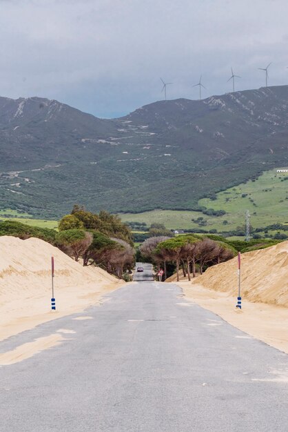 Foto estrada que leva para as montanhas contra as dunas do céu