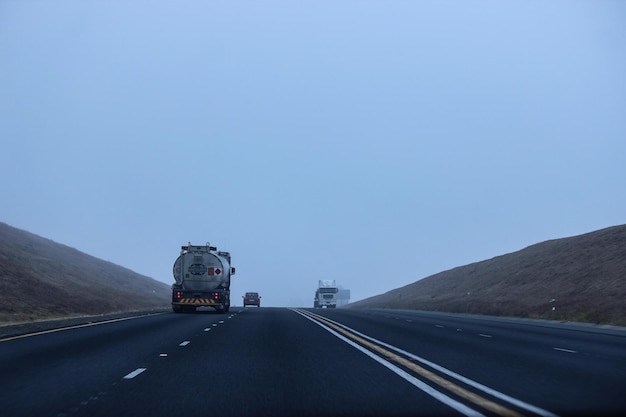 Foto estrada que leva para as montanhas contra o céu azul