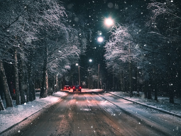 Estrada rural de inverno à noite com o carro.