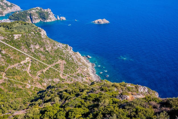 Estrada serpentina nas montanhas cobertas de floresta vista incrível da ilha de corfu drone grécia água azul clara vista aérea fotoincrível no mar jônico baía de palaiokastritsa