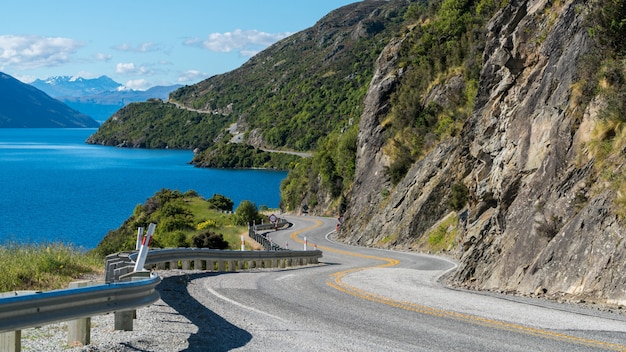 Estrada sinuosa ao longo do penhasco da montanha e lago