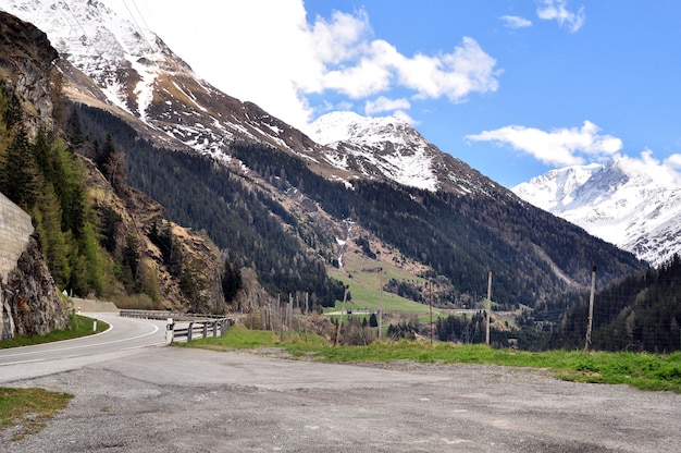 Estrada sinuosa entre picos de montanhas cobertas de neve