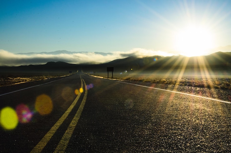 Foto estrada vazia ao longo da paisagem durante um dia ensolarado