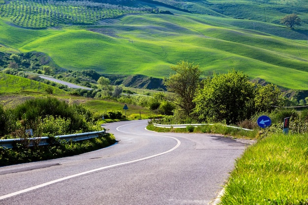 Estrada vazia e colina verde na Toscana, Itália