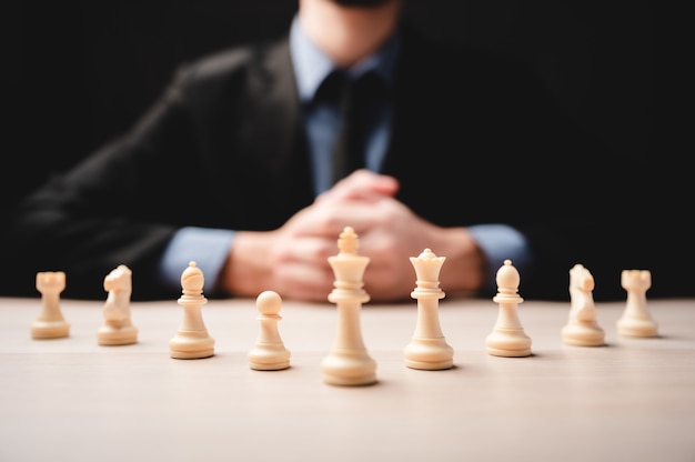 Estrategia de ajedrez para liderazgo empresarial y equipo en concepto de éxito, competencia de líder de rey del juego con desafío de poder de trabajo en equipo, pieza de peón jugando a bordo, inteligencia de victoria del tablero de ajedrez