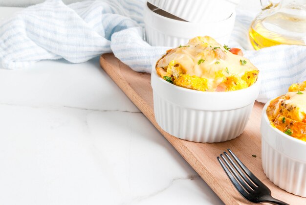 Estratos caseiros da caçarola de pão italiano com queijo, ovo e presunto, espaço branco da cópia do fundo