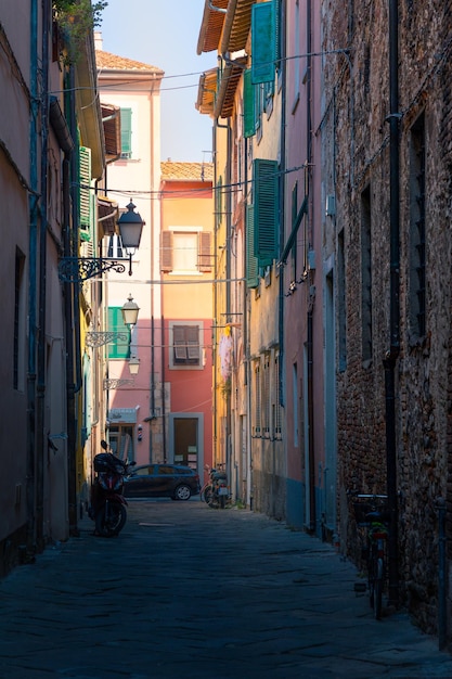 Estrecha calle medieval vacía de una ciudad europea con viejos edificios residenciales coloridos Pisa Italia