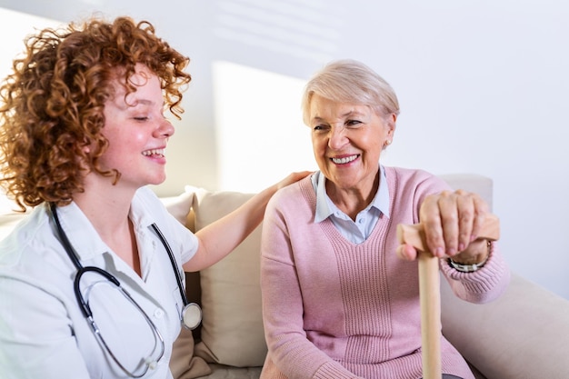 Una estrecha relación positiva entre el paciente mayor y el cuidador Una mujer mayor feliz hablando con un cuidador amigable Una joven cuidadora bonita y una mujer mayor feliz