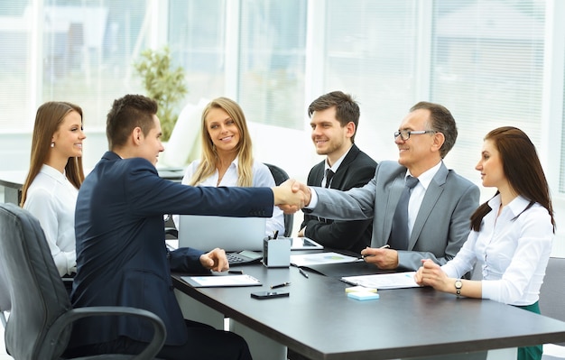 Estrechar la mano durante una reunión de negocios socios comerciales en la oficina