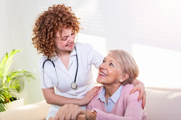 Estreita relação positiva entre paciente sênior e cuidador. feliz mulher sênior falando com um cuidador amigável.