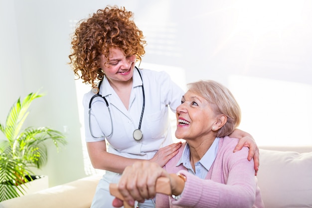 Estreita relação positiva entre paciente sênior e cuidador. Feliz mulher sênior falando com um cuidador amigável.