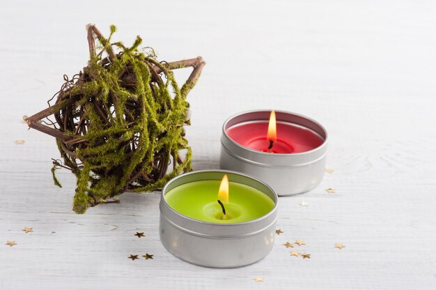 Estrela decorativa com musgo e velas acesas verdes e vermelhas