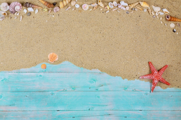 Estrela do mar vermelha com conchas do mar na areia do mar na superfície de madeira azul
