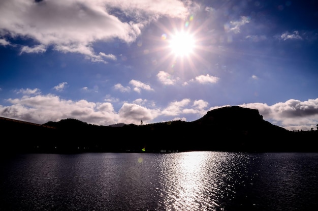 Estrela do sol em um céu azul sobre uma silhueta de montanha em Gran Canaria, Espanha