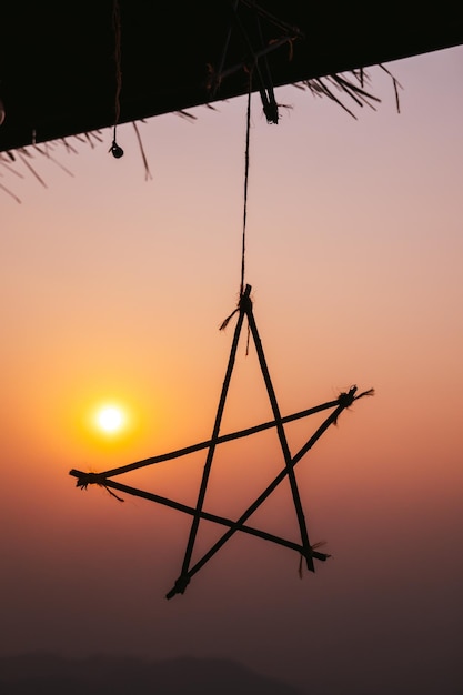 Estrela pendurada em silhueta no fundo do pôr do sol