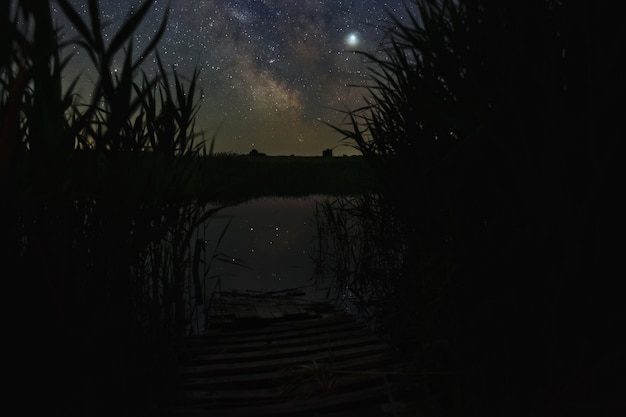 Estrelas brilhantes da Via Láctea sobre o rio no céu noturno