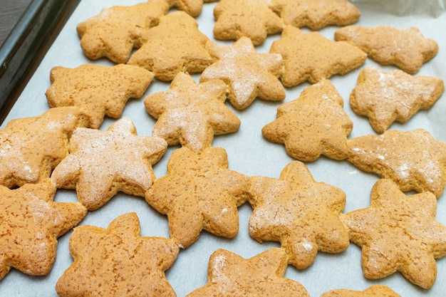 Estrelas caseiras tradicionais de Natal de Ano Novo e biscoitos em forma de abeto, processo de preparação de biscoitos