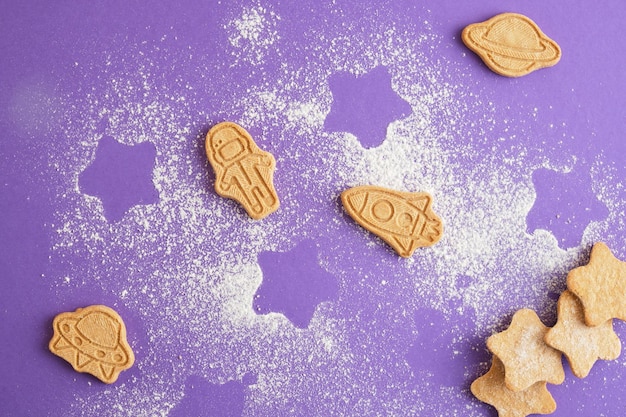 Foto estrelas de biscoitos e astronauta para biscoitos do dia mundial da cosmonáutica em fundo roxo conceito de espaço e astronomia