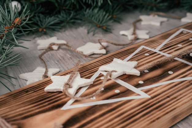 Estrelas de Natal, guirlanda de porcelana fria caseira com ramos de abeto e desenho de uma árvore de Natal a bordo