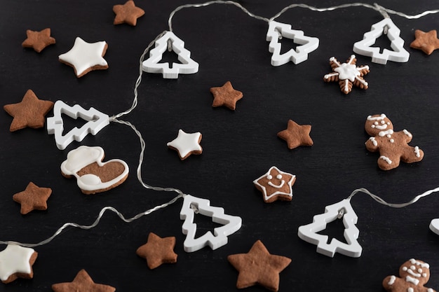 Estrelas de pão de gengibre de Natal e abeto em fundo preto Vista superior