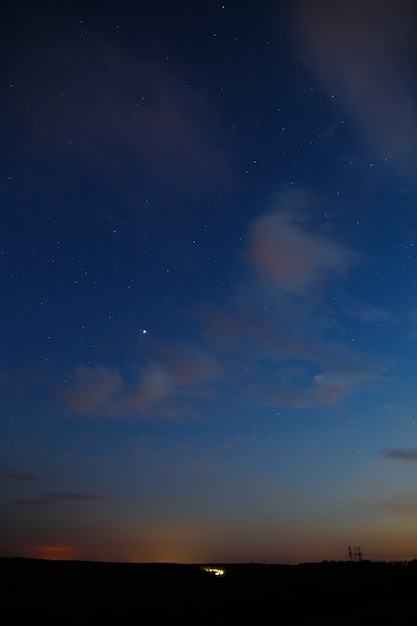 Estrelas e nuvens no céu após o pôr do sol.