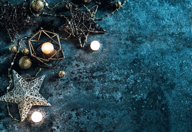 Estrelas, luzes e velas de decoração de Natal em fundo azul escuro