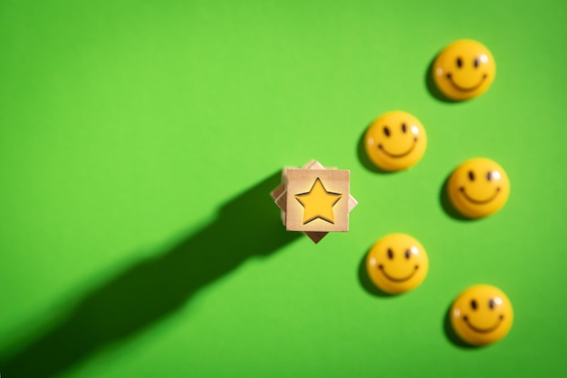 Estrella en cubo de madera y caras sonrientes felices