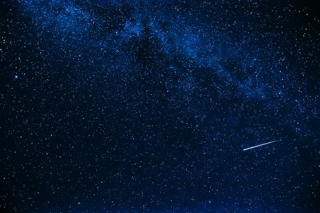 Estrella fugaz en el fondo de un cielo azul estrellado por la noche