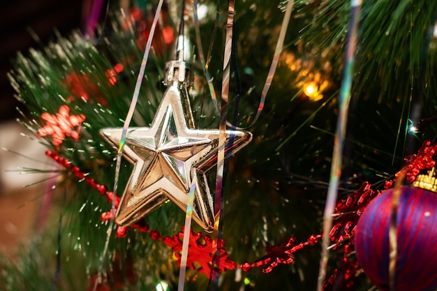 Estrella de juguete de árbol de Navidad en el fondo de ramas de abeto de Año Nuevo