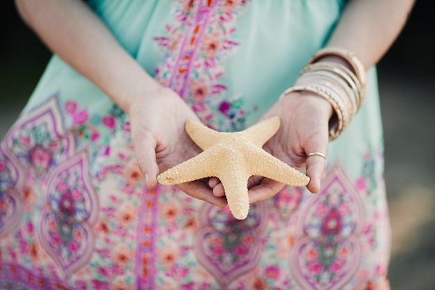 Estrella de mar blanca en manos de una niña