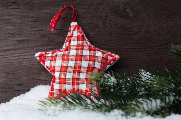 Estrella de Navidad y árbol en la nieve sobre madera