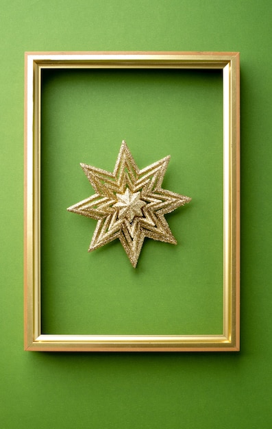 Foto estrella de navidad chispeante con marco dorado en verde