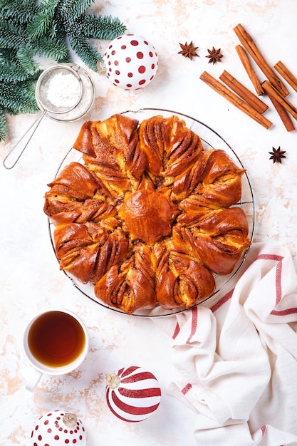 Estrella de Navidad trenzado pan de chocolate y canela sobre mesa de madera blanca. Copie el espacio para el texto. Vista superior