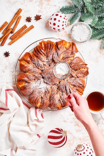 Estrella de Navidad trenzado pan de chocolate y canela sobre mesa de madera blanca. Copie el espacio para el texto. Vista superior