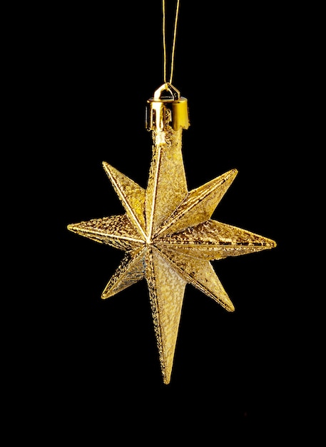 Estrella de oro (en) sobre fondo negro, adorno navideño