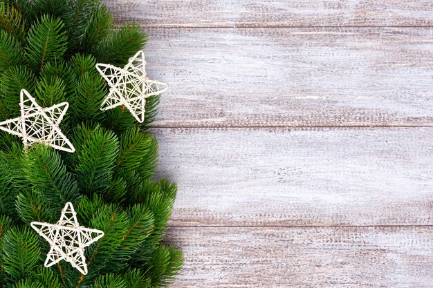 Estrella de plata y adornos en ramas de abeto sobre un fondo de madera