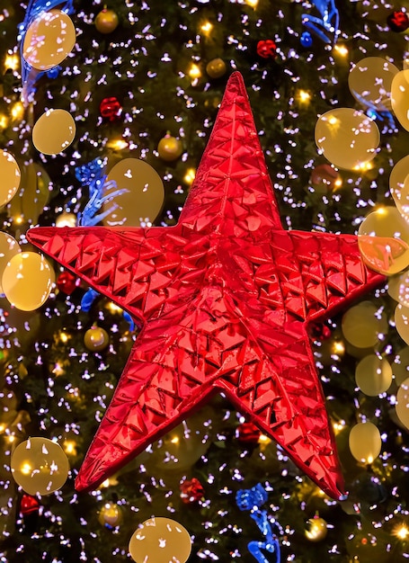Foto estrella roja del árbol de navidad con luces bokeh en la ciudad