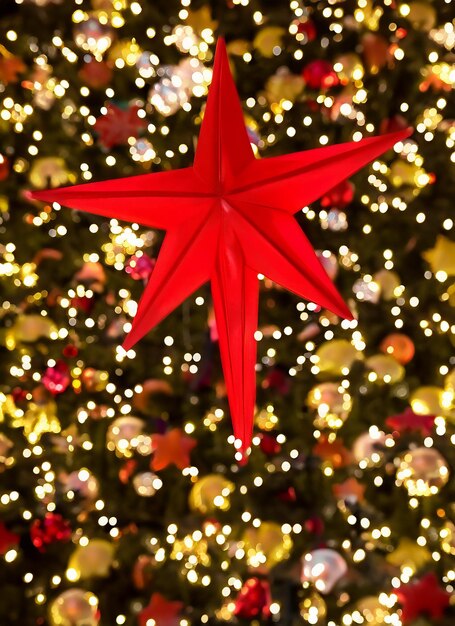 Foto estrella roja del árbol de navidad con luces bokeh en la ciudad