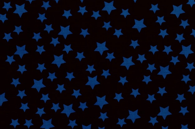 Estrellas azules sobre lienzo negro textura de algodón