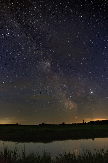 Estrellas brillantes de la Vía Láctea sobre el río en el cielo nocturno