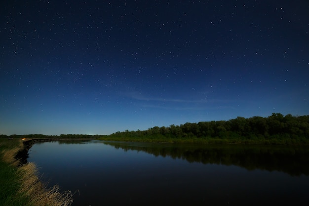 Las estrellas en el cielo nocturno se reflejan en el río.