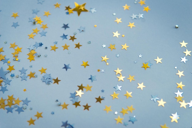 Estrellas de confeti dorado en la vista superior de fondo azul