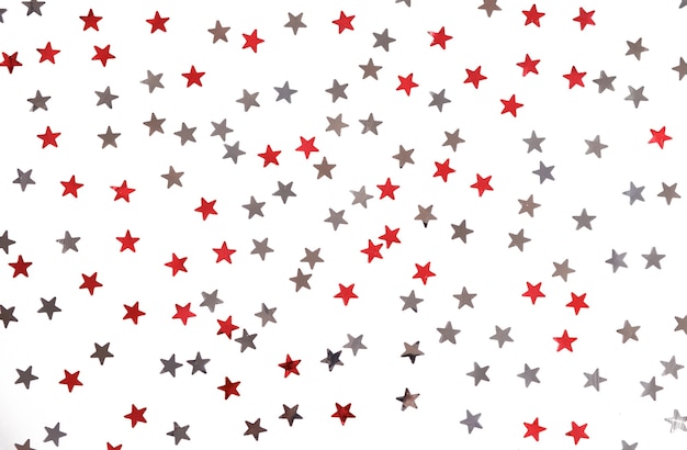 Las estrellas rojas y plateadas brillan sobre un fondo blanco aislado.