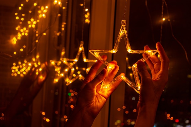 Estrellas en la ventana. Decoración navideña con guirnaldas de luces y estrellas en las vacaciones de invierno.