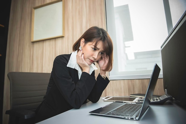 El estrés asiático de la mujer de negocios que trabaja falla. El dueño de la empresa la culpó con malas palabras. El jefe se quejaba de las ventas.