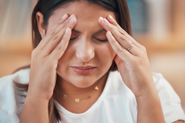 Estrés de dolor de cabeza y ansiedad con una mujer de negocios que sostiene su cabeza con dolor mientras siente presión Agotamiento de la salud mental y migraña con una empleada que lucha por cumplir con la fecha límite del proyecto