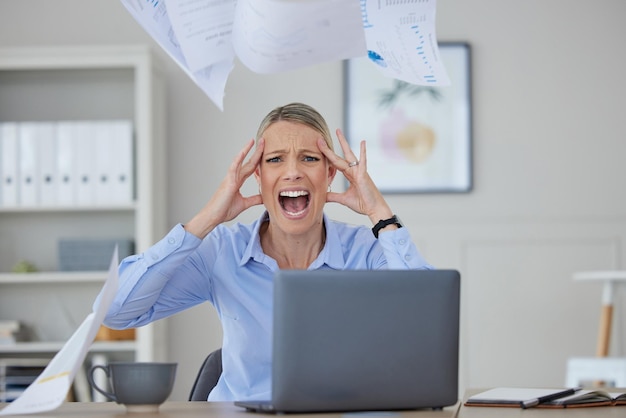 Estrés enojado y mujer gritando en el escritorio de su oficina con frustración y miedo en los problemas de trabajo Rabia de pánico grave o dolor de cabeza por noticias sobre impuestos de auditoría o bancarrota mientras está en un trabajo corporativo