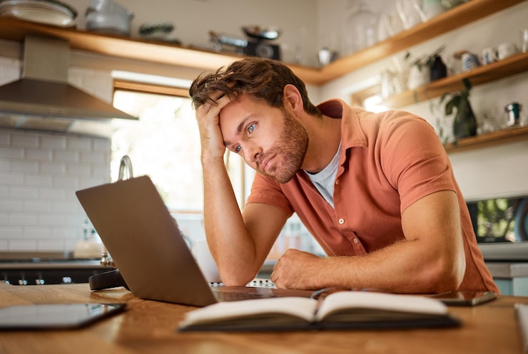 Foto estrés en las finanzas de las computadoras portátiles y el hombre de planificación que piensa en los ahorros de inversión de préstamos hipotecarios y los objetivos futuros de crecimiento del dinero en la cocina de la casa agotamiento de ansiedad o tipo triste con depresión de la deuda después del presupuesto comercial