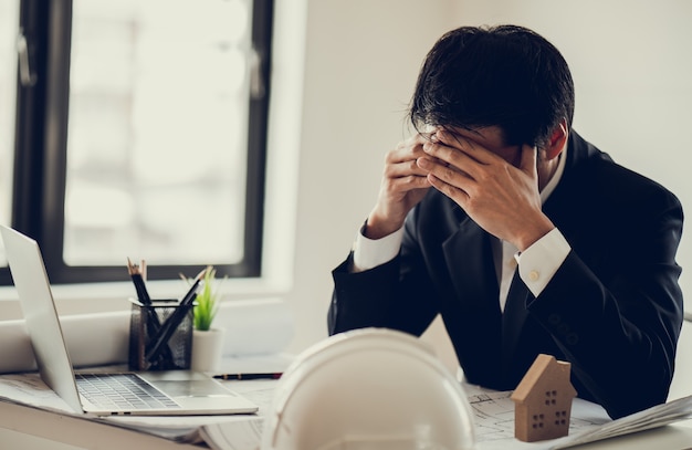 El estrés del hombre de negocios y la preocupación por el retraso en la finalización del proyecto de construcción